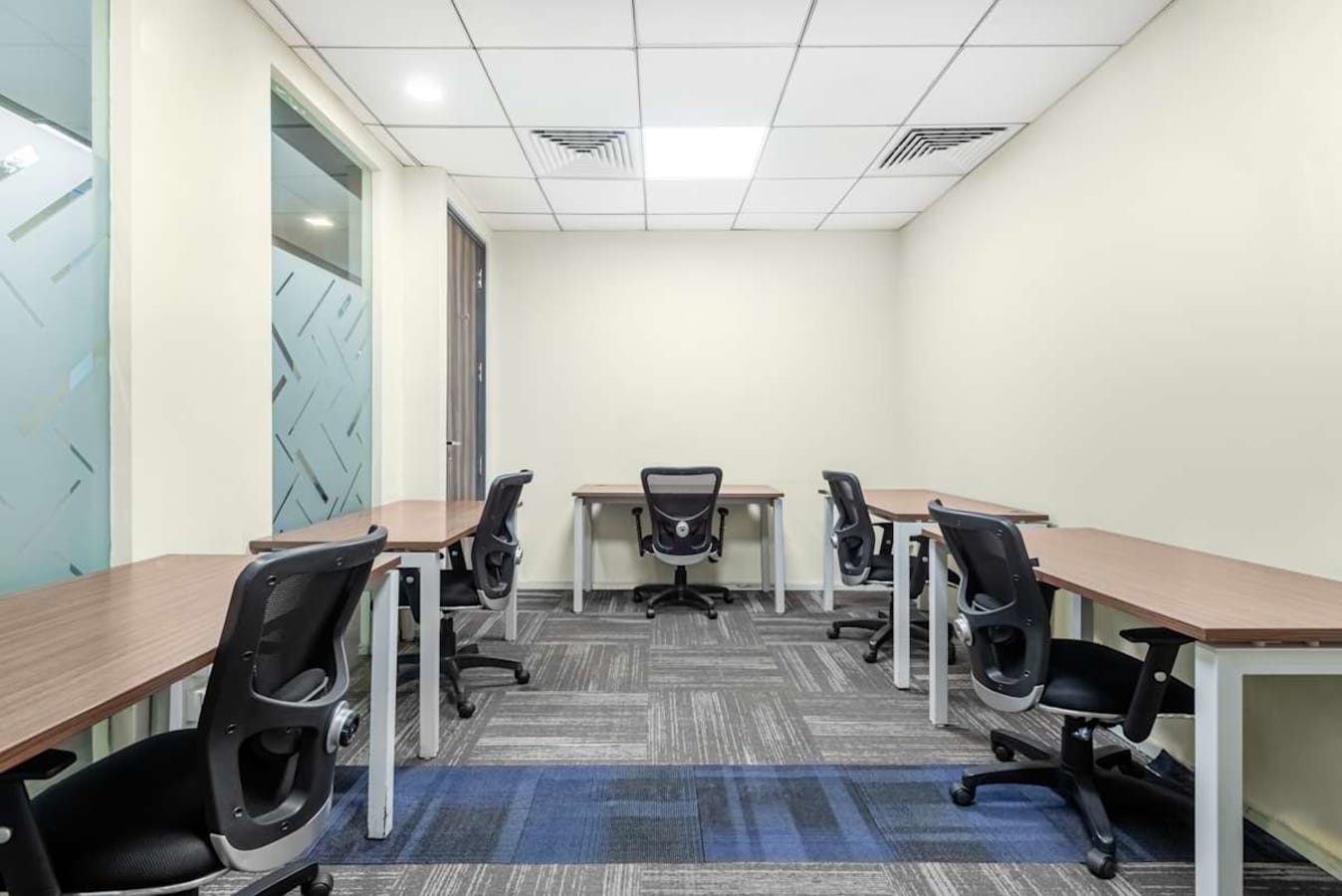 Modern coworking space with ergonomic chairs, individual desks, and ample lighting on Old Airport Road.