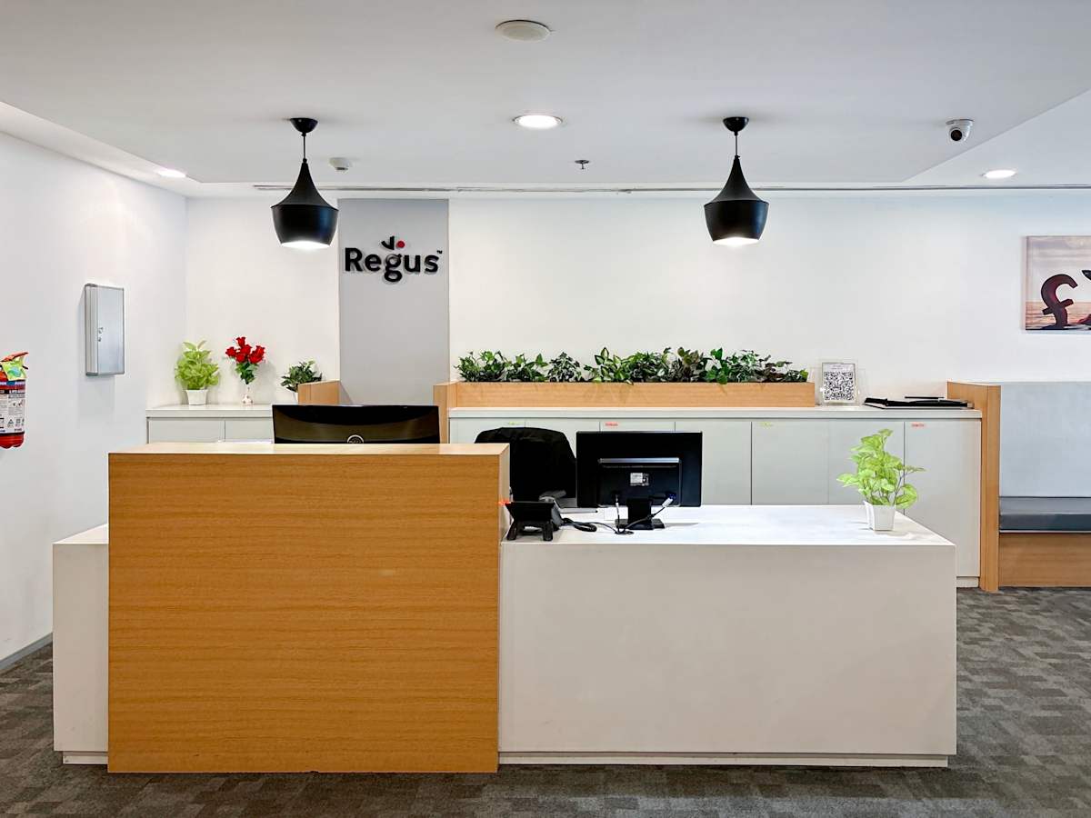 Modern coworking area with sleek reception, ample lighting, and greenery in Northern Access Road.