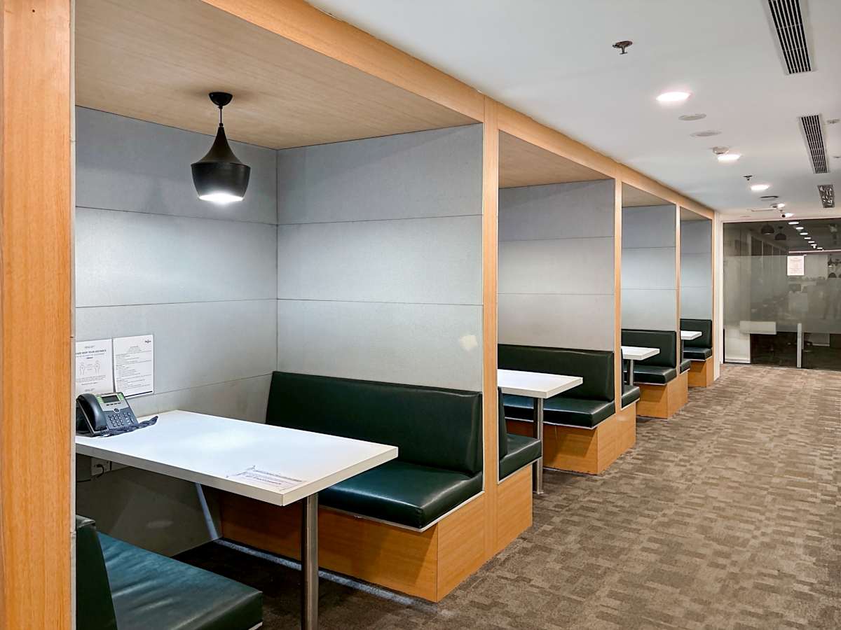 Modern coworking booths with sleek seating and ample lighting in Northern Access Road, Delhi.