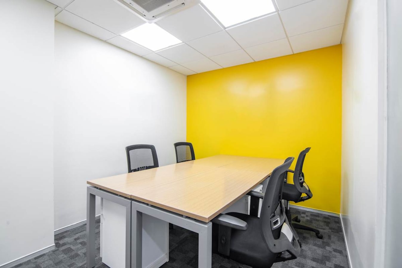 Bright, modern workspace with vibrant accent wall and ergonomic chairs in Lane Number 7, Maharashtra.
