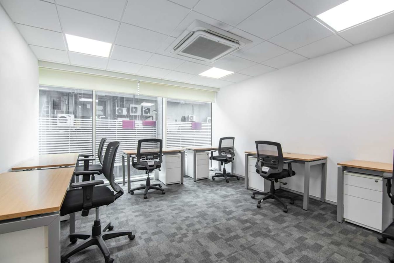 Bright coworking space with ergonomic chairs, natural light, and a modern, minimalist design.