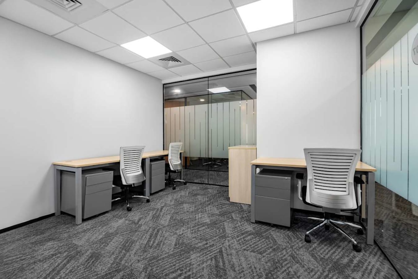 Modern coworking space with sleek desks, ergonomic chairs, and ample natural light.