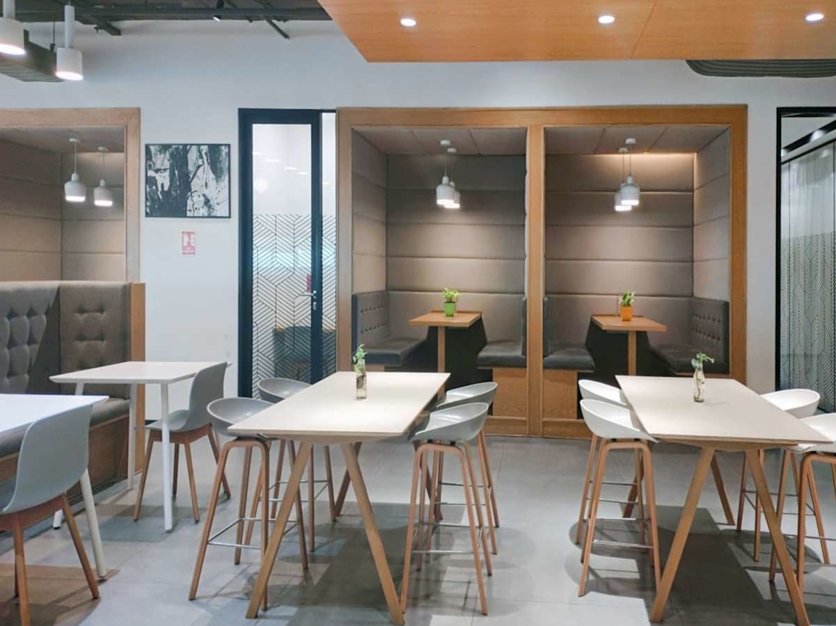 Modern coworking space with cozy booths and communal tables, ideal for collaboration.