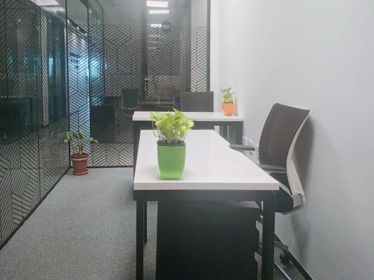 Modern coworking space with glass partitions and sleek furnishings on Embassy Golf Links Road.