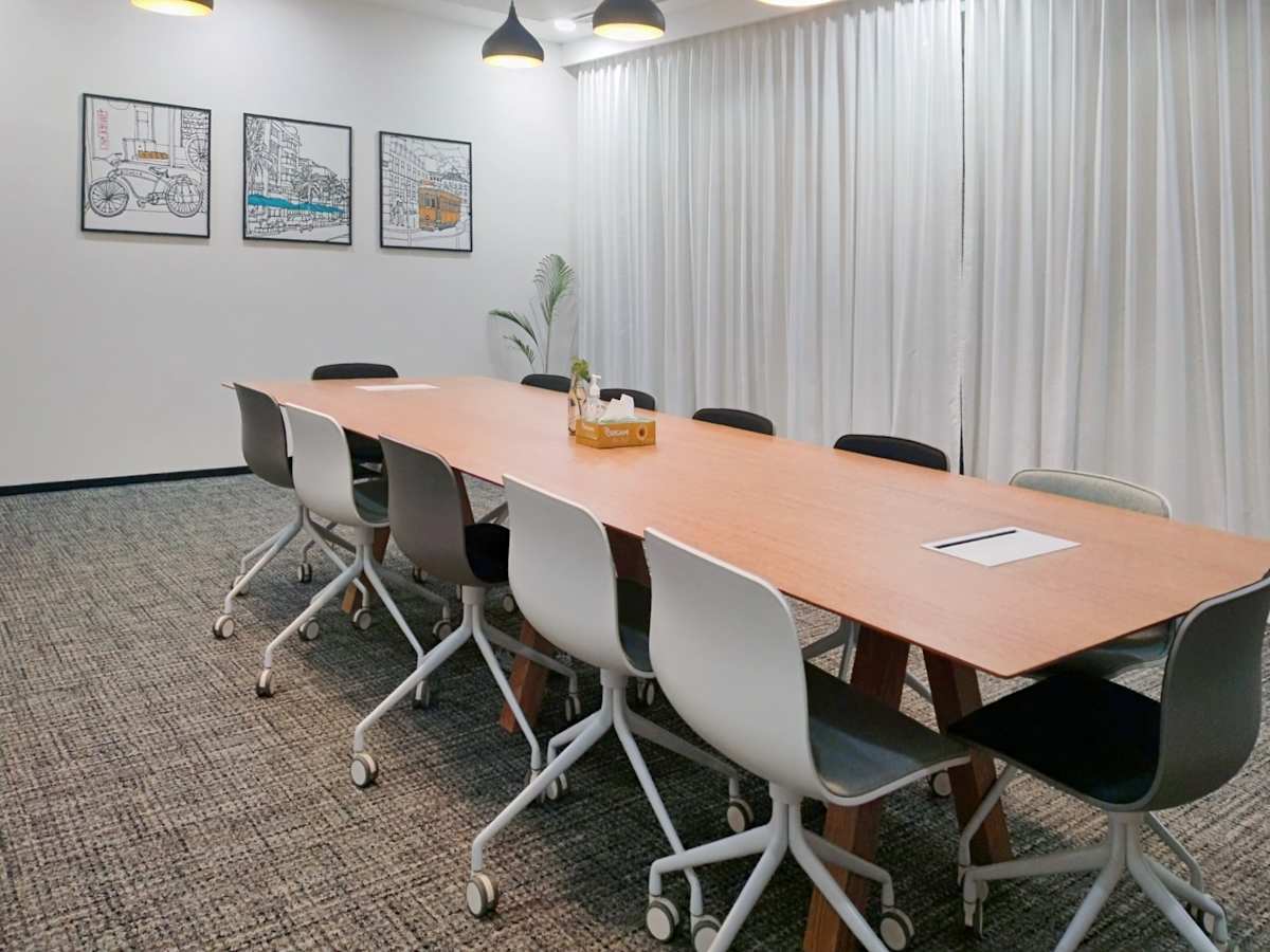 Spacious meeting room with modern seating and natural light. Ideal for collaborative work.
