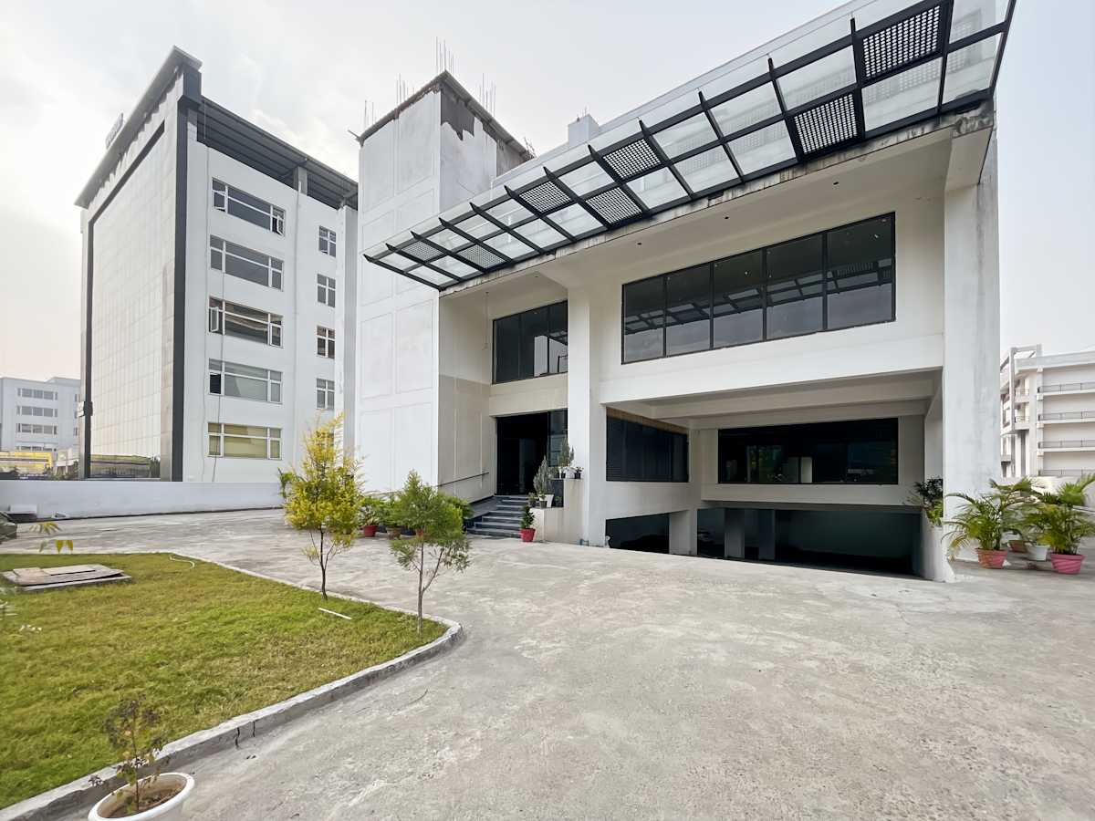 Modern coworking space with sleek exterior on Sahastradhara Road. Spacious with ample natural light.