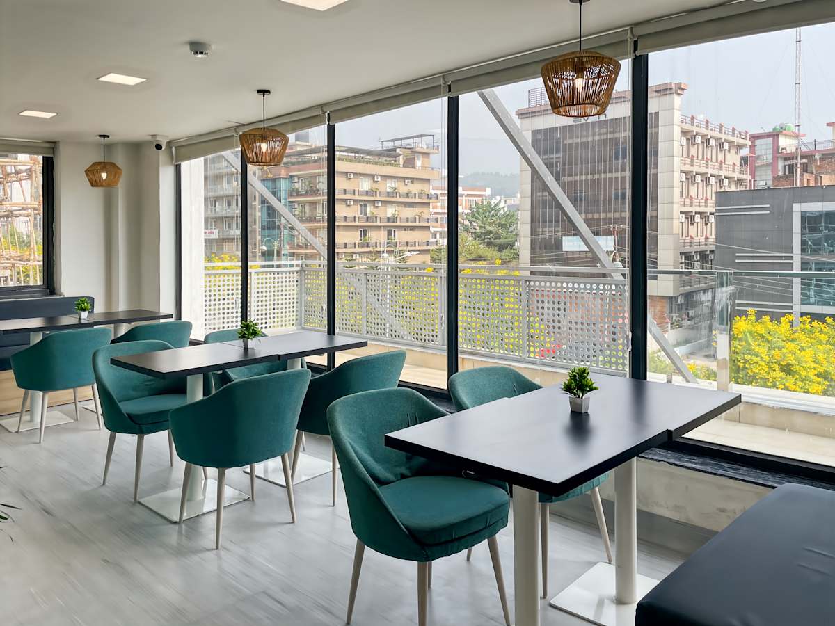 Bright coworking space with modern seating, panoramic windows, and stunning city views.