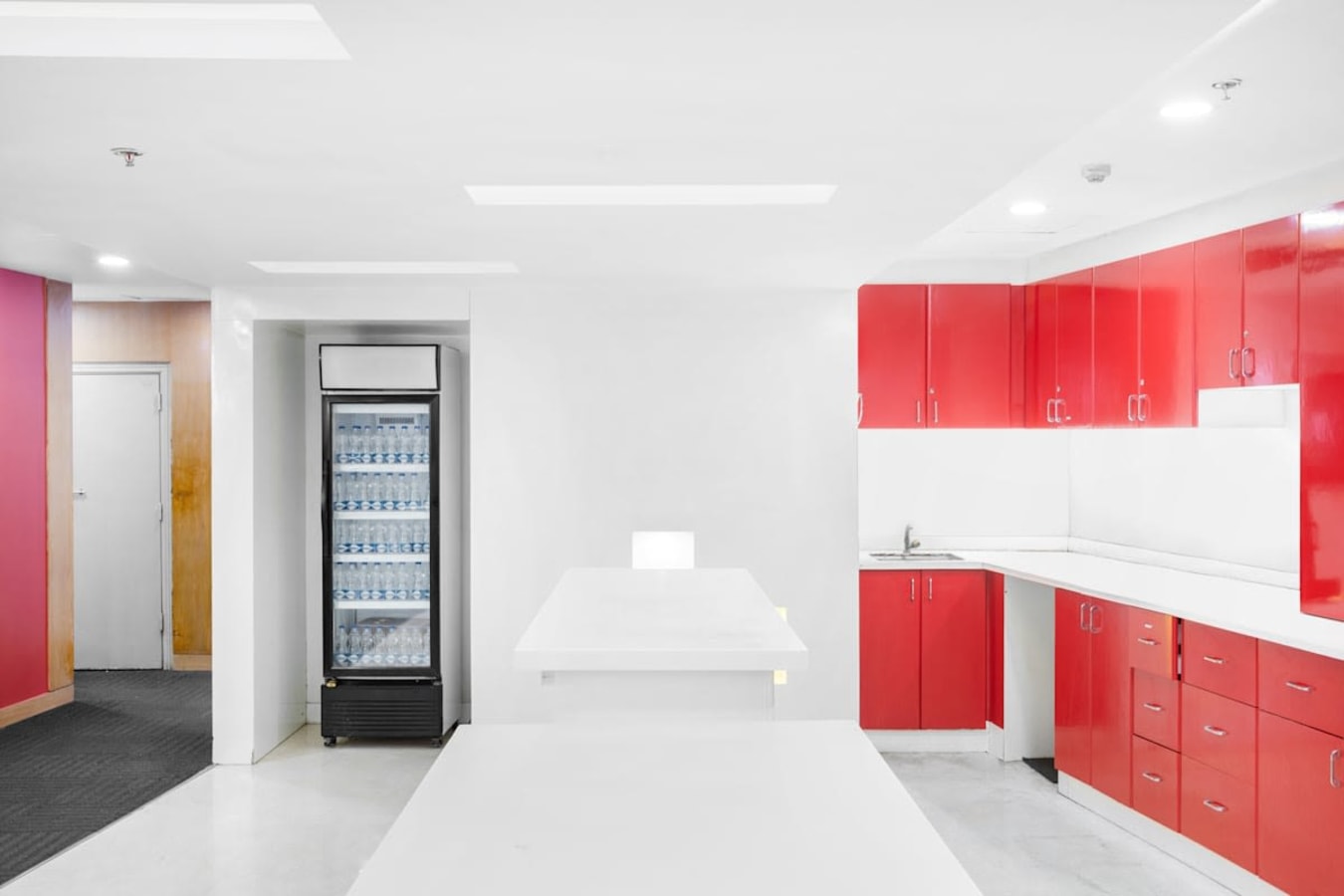 Modern coworking kitchen with vibrant red cabinetry and ample counter space for collaboration.