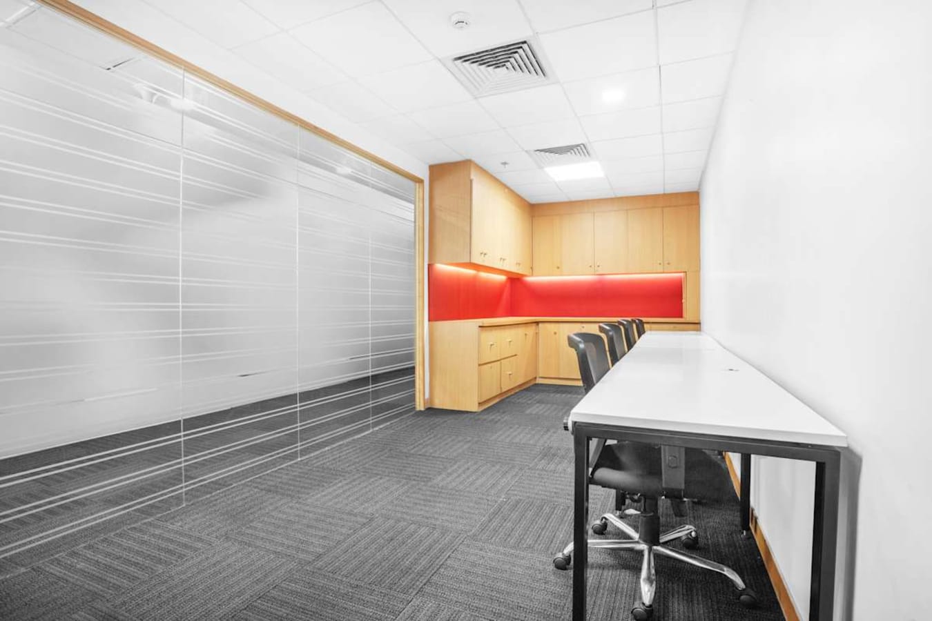Modern coworking space with sleek workstations, vibrant accents, and ample natural light.