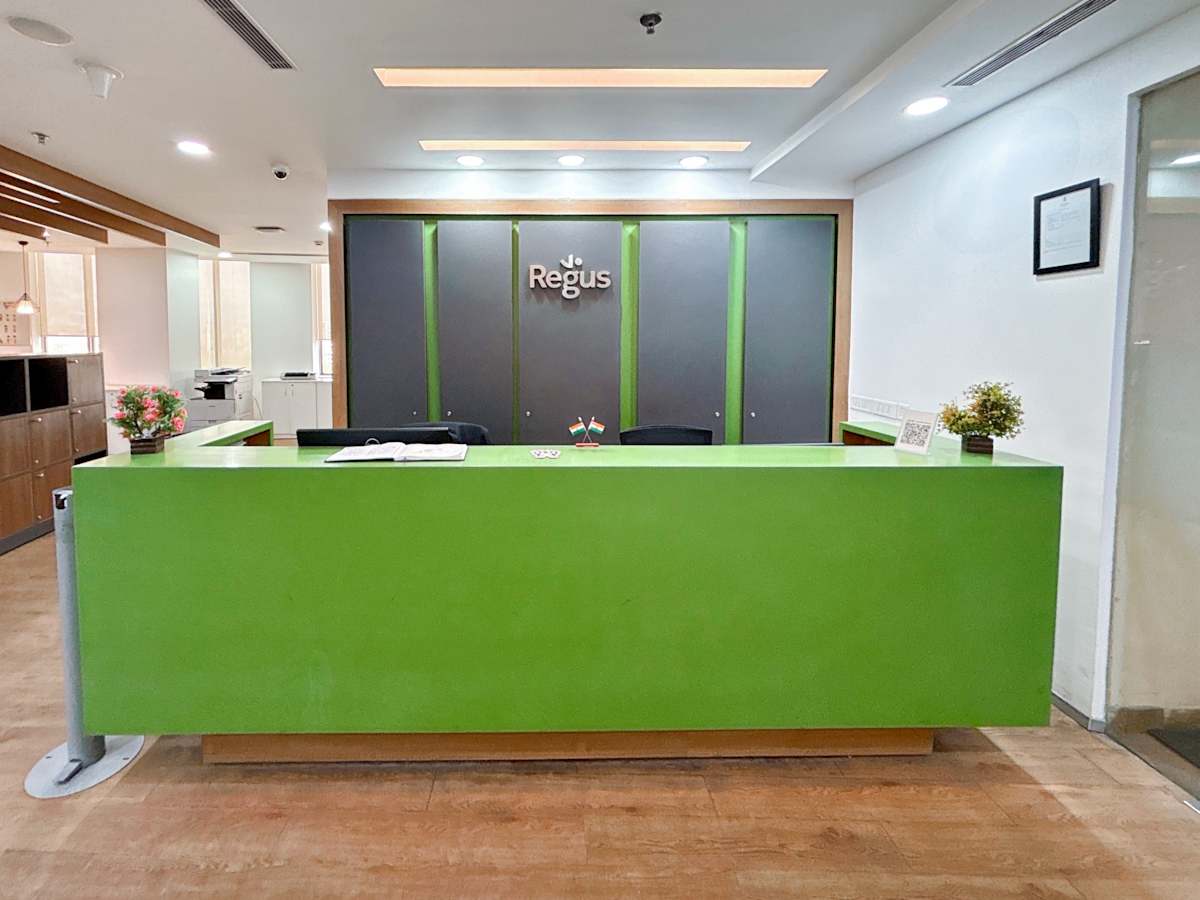 Modern reception area with vibrant green desk and sleek design in Sale Shop coworking space.