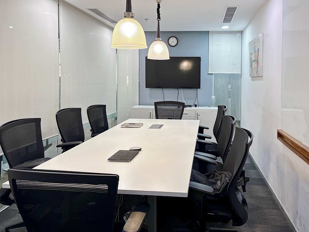 Modern conference room with ergonomic chairs, ample lighting, and a large screen for presentations.