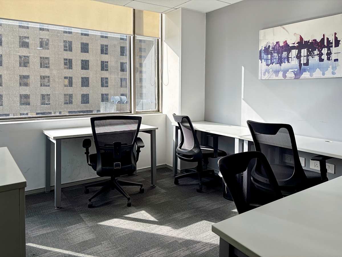 Bright coworking space with modern desks and ergonomic chairs, offering a productive environment.
