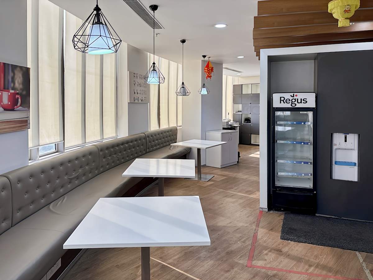 Bright coworking space with modern seating, stylish lighting, and a convenient refreshment area.