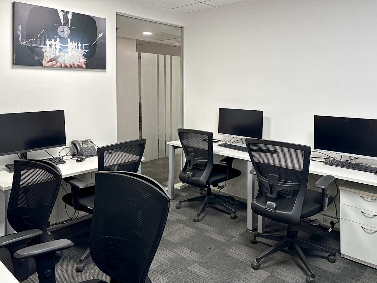 Modern coworking space with ergonomic chairs, spacious desks, and sleek monitors. Ideal for productivity.