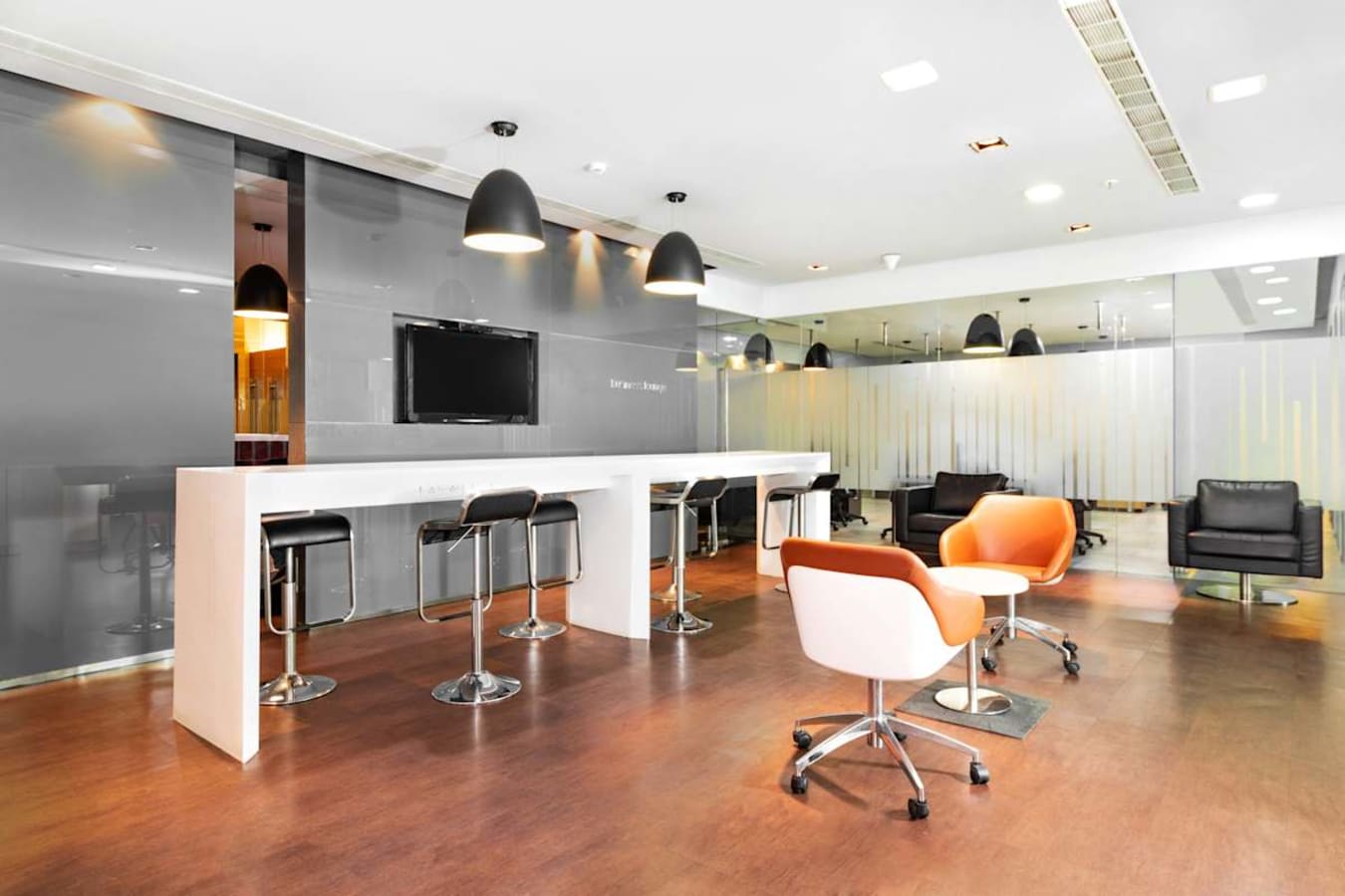 Sleek coworking area with modern seating, high-top counters, and ample lighting on Rajkumar Road.
