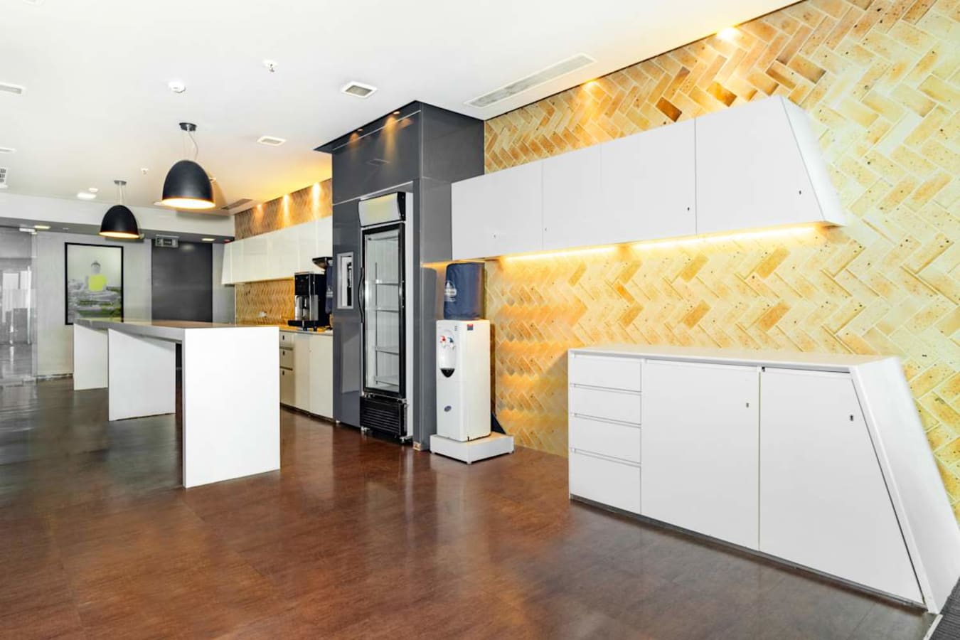 Modern coworking space with sleek cabinetry, ambient lighting, and ample countertop space.