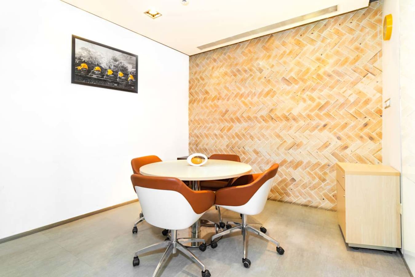 Stylish coworking space with modern chairs and herringbone accent wall. Ideal for collaboration.