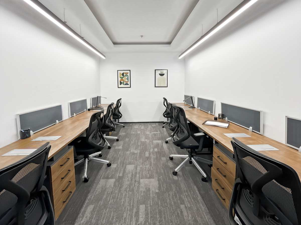 Modern coworking space with ergonomic chairs, ample desk space, and sleek lighting.