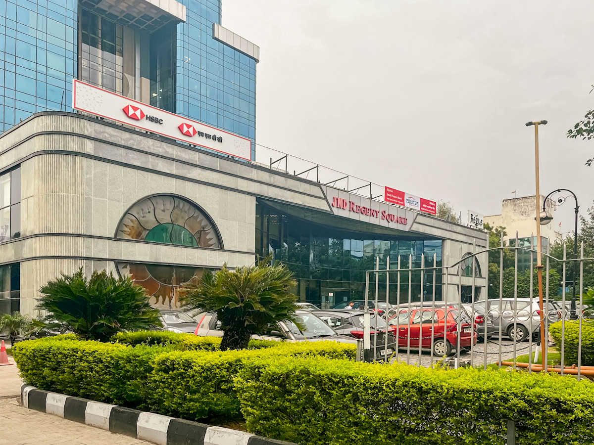 Modern coworking space on Mehrauli-Gurgaon Road with ample parking and lush greenery.