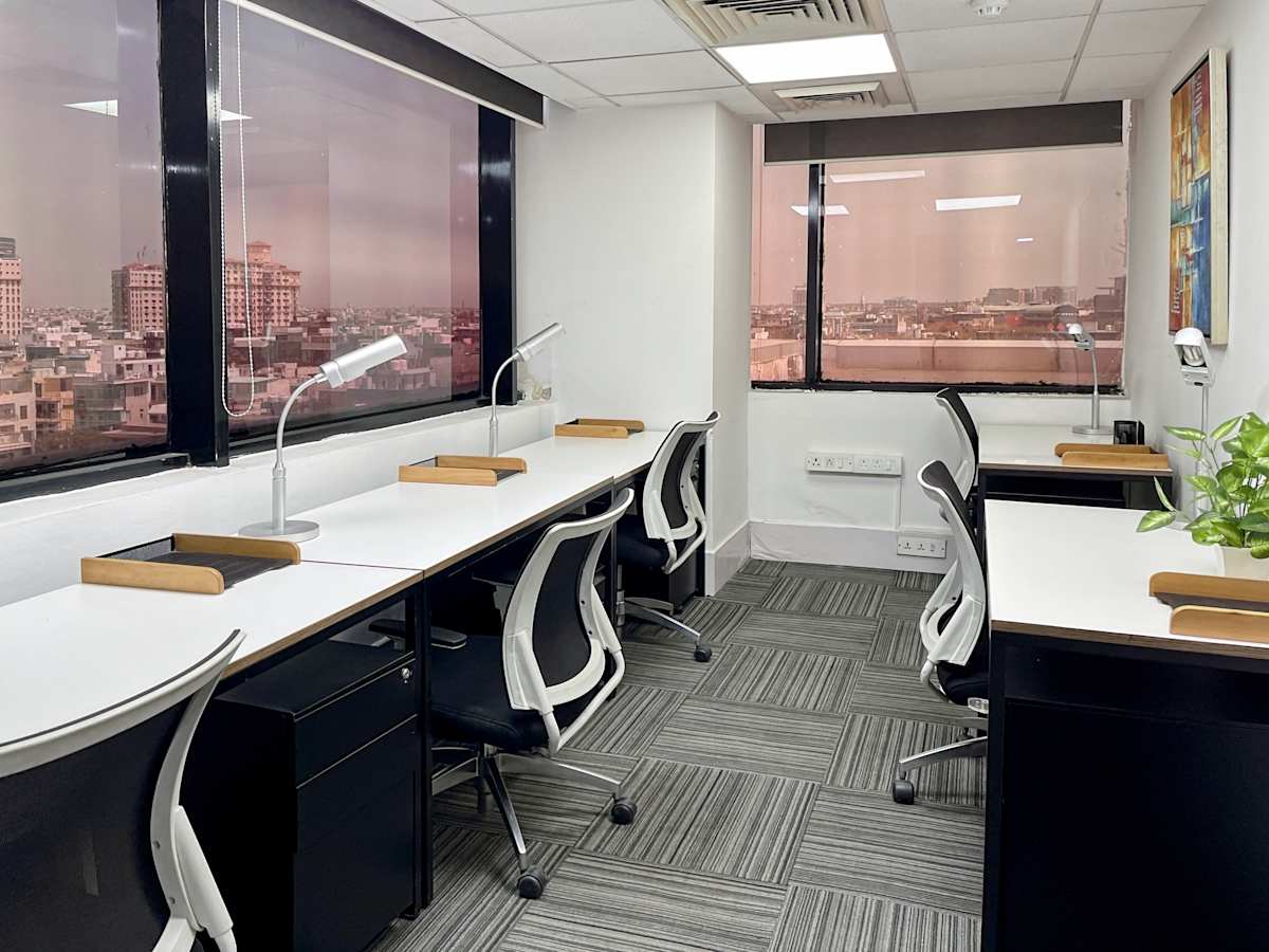 Modern coworking space with ample natural light, ergonomic chairs, and city views.