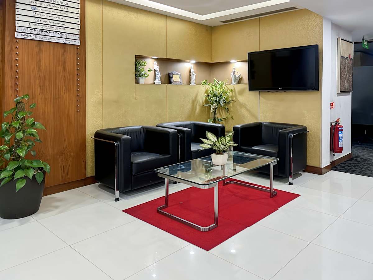Inviting lounge area with modern seating, glass table, and vibrant decor in a coworking space.