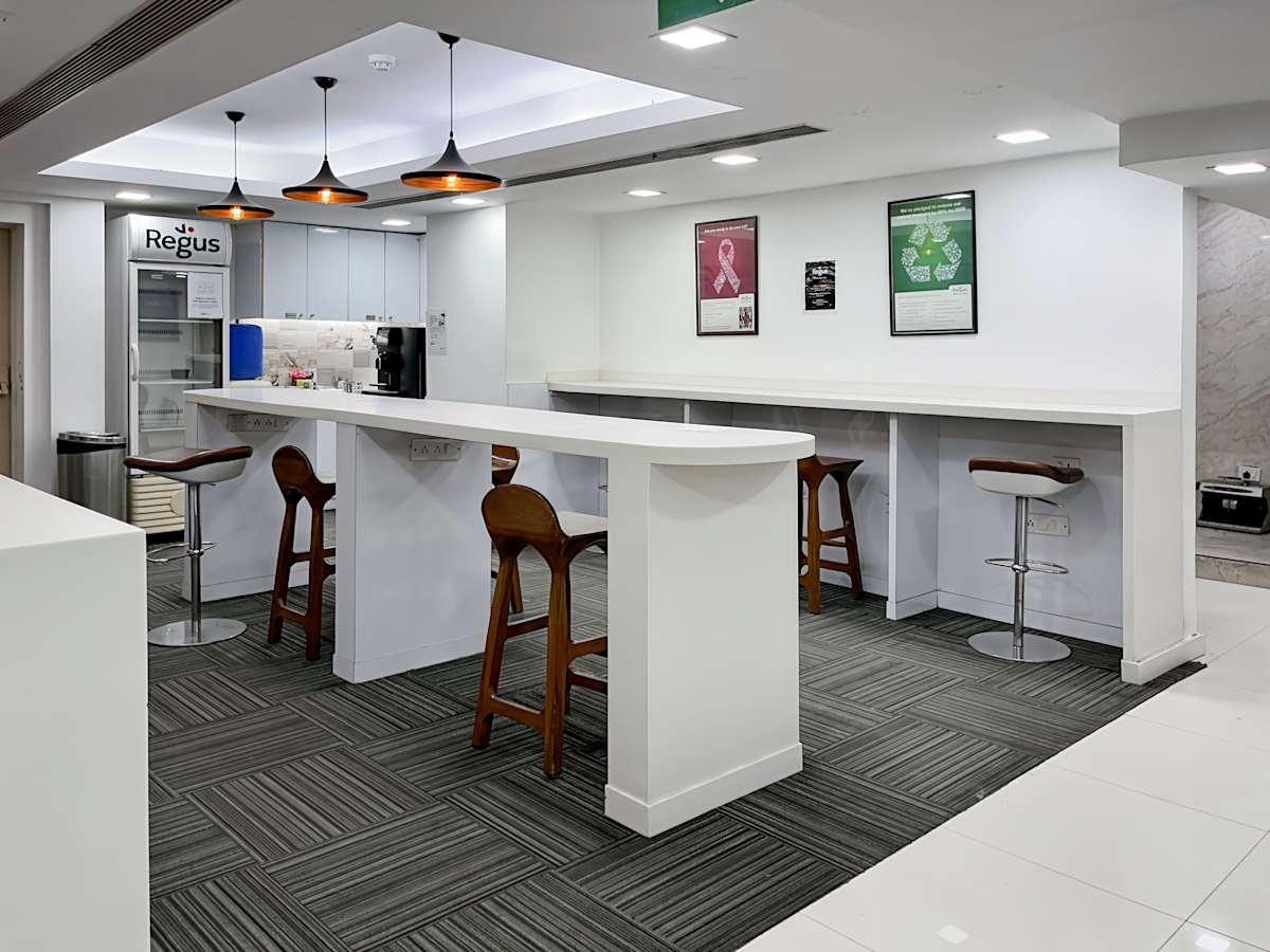 Modern coworking space with sleek high tables, ergonomic stools, and bright lighting.