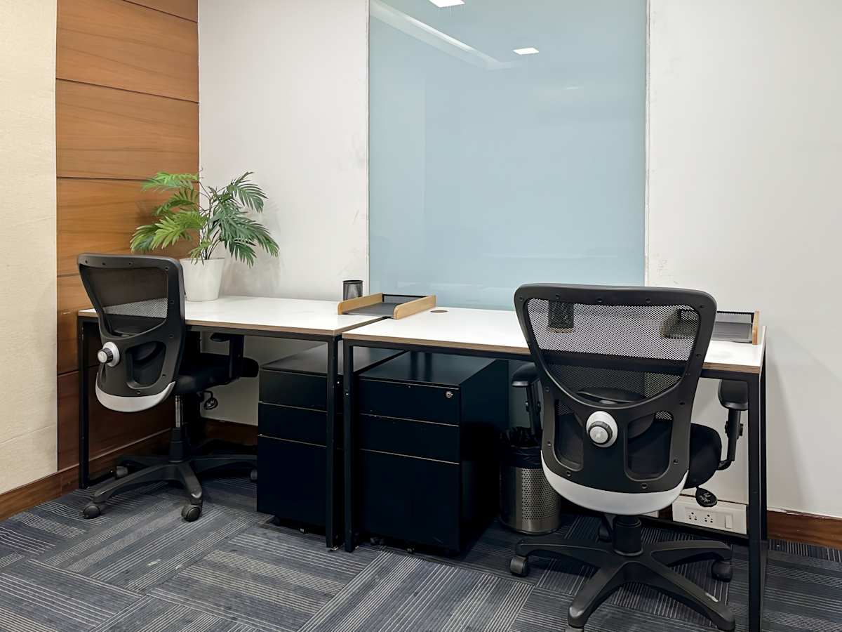 Modern coworking space with ergonomic chairs, ample desk space, and vibrant greenery.