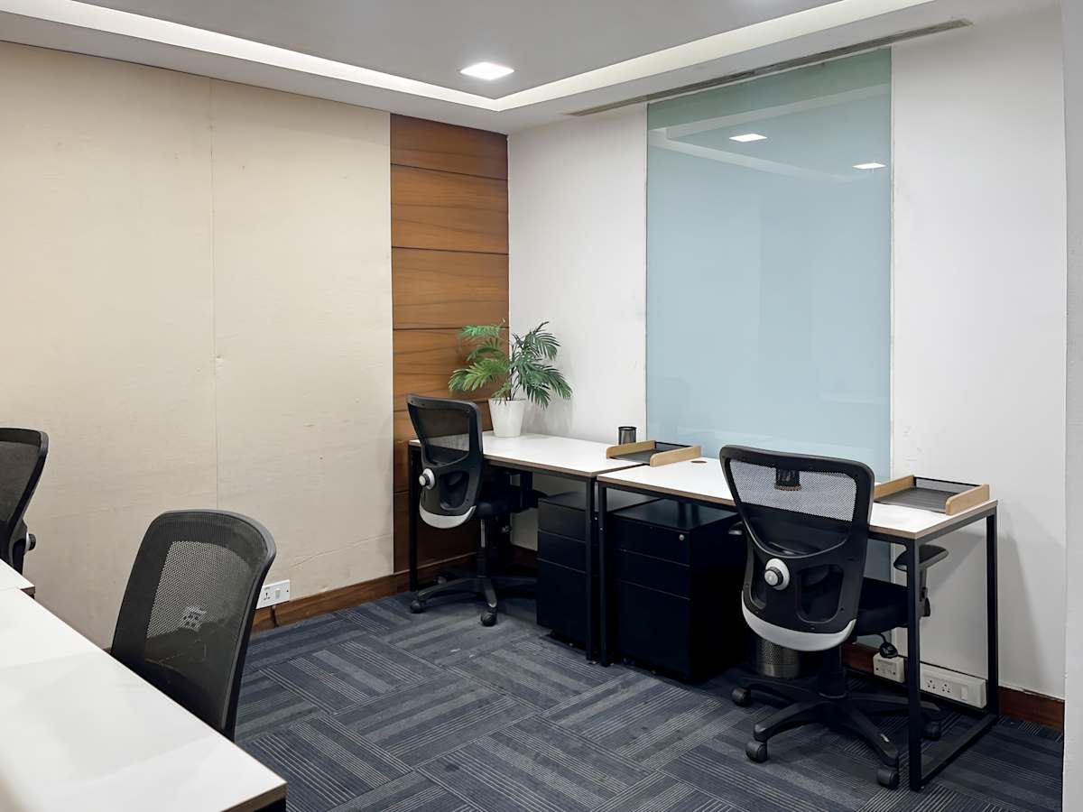 Modern coworking space with ergonomic chairs, ample desk space, and warm lighting.