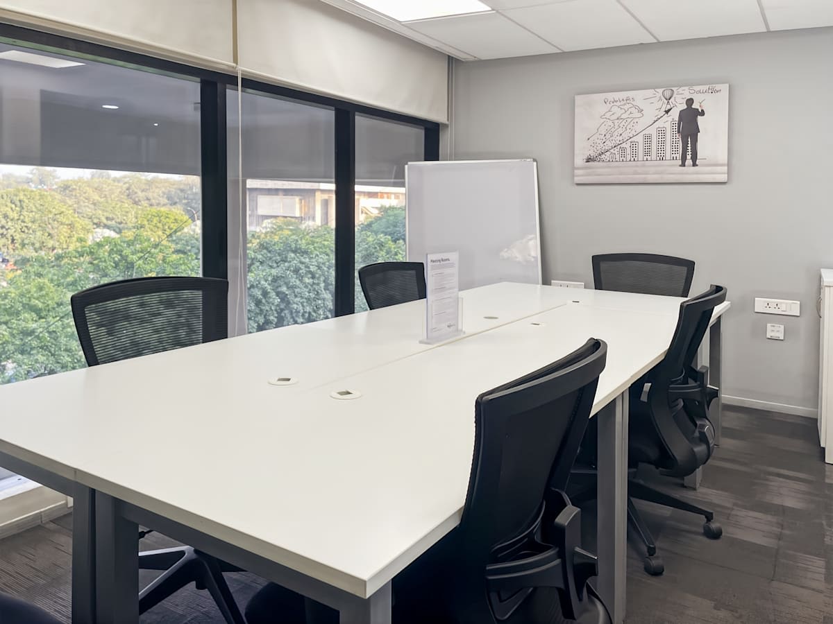 Bright coworking area with large windows, modern furnishings, and a scenic view in Sector 17A.