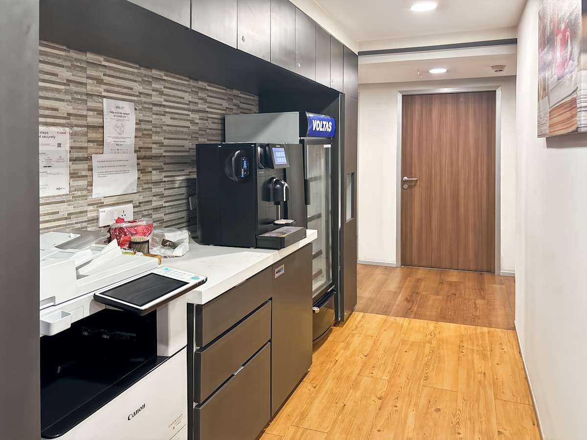 Modern coworking pantry with printer, coffee station, and ample storage in Sector 17A, Chandigarh.