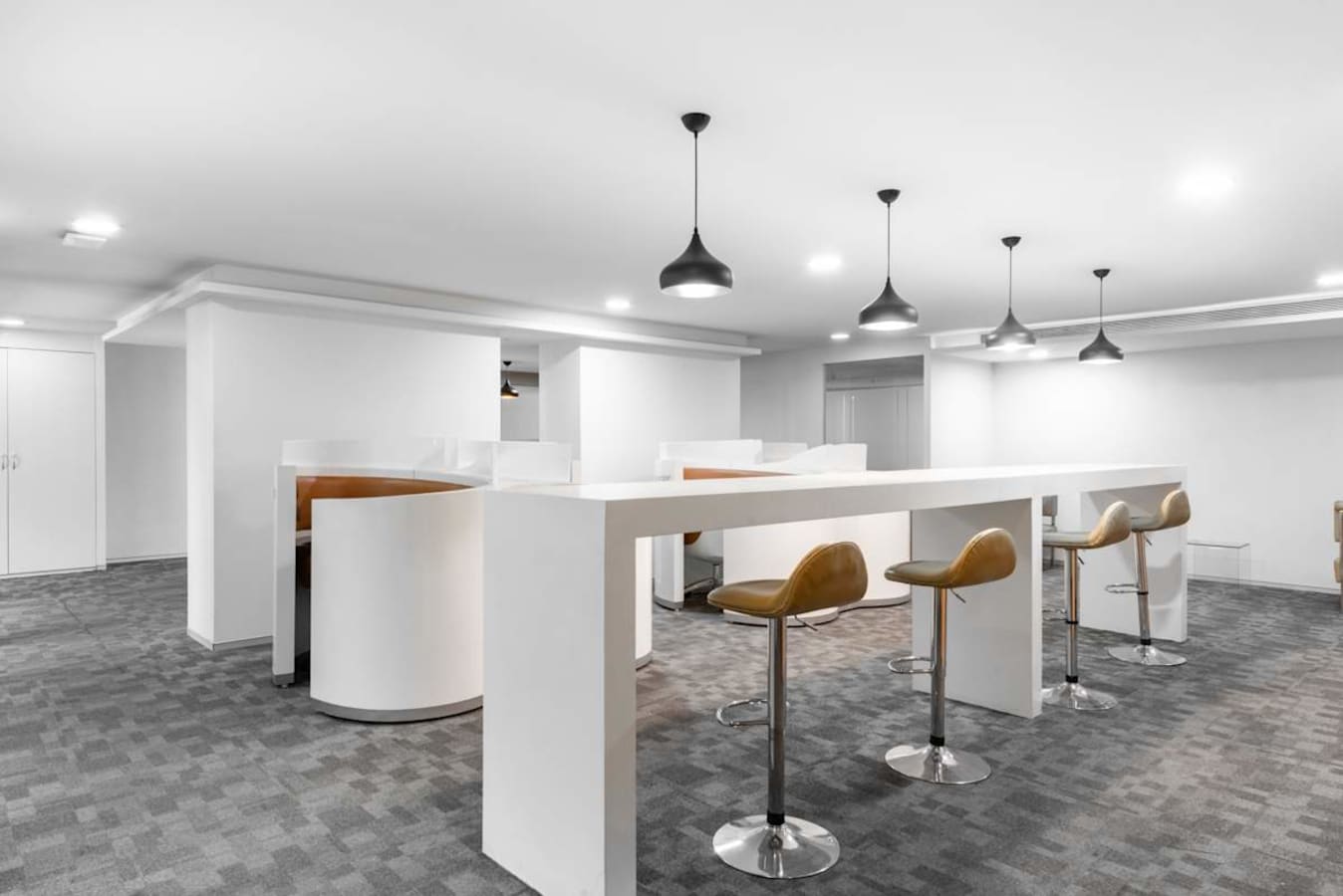 Modern coworking area with high desks and barstool seating, ideal for collaboration.