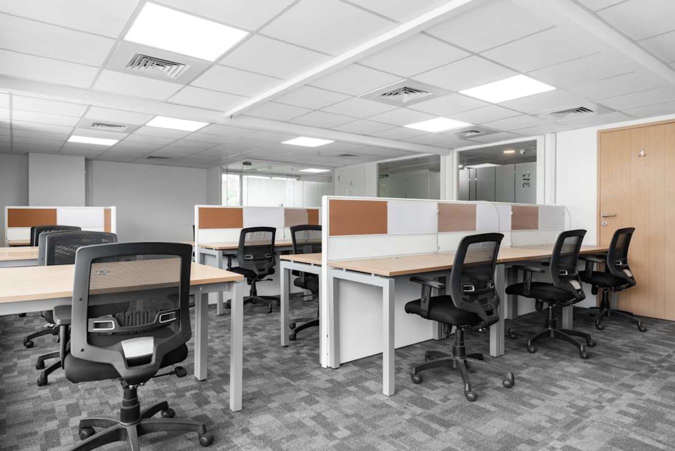 Modern coworking space with ergonomic chairs, ample lighting, and a collaborative setup.