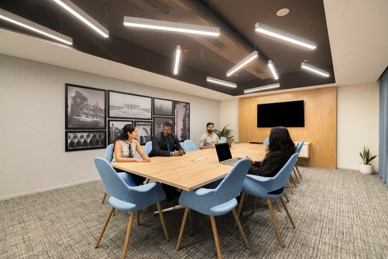 Modern coworking space with stylish lighting, cozy seating, and a collaborative meeting area.