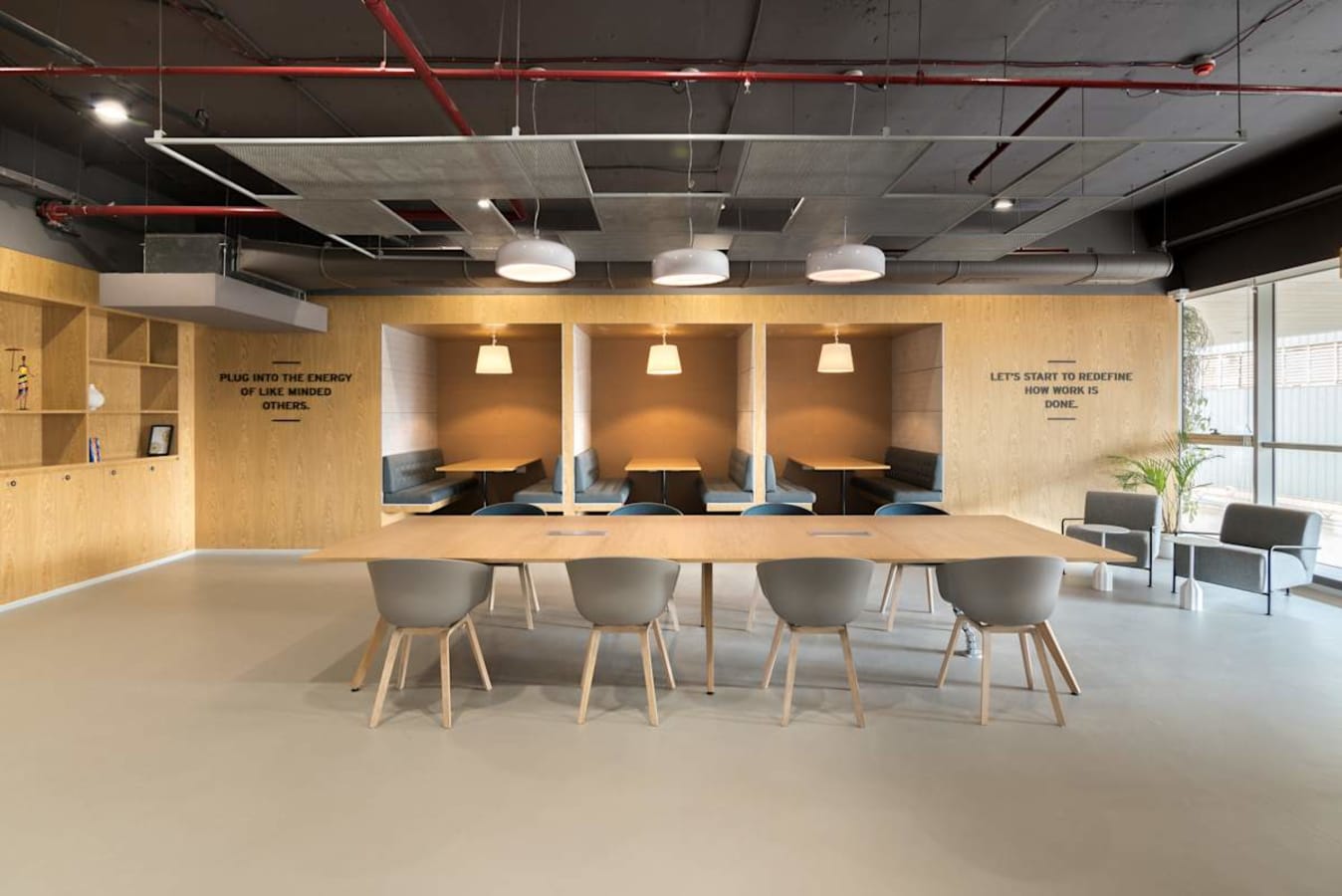 Modern coworking space with open seating, cozy booths, and abundant natural light.