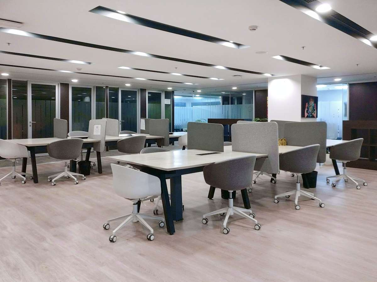 Modern Gurugram coworking space with open layout, stylish desks, and ample natural light.