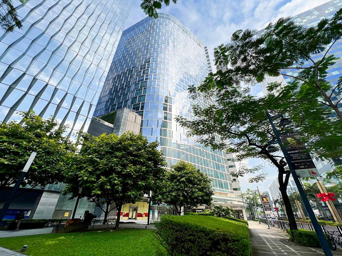 Modern coworking space on Metro Manila's 5th Avenue, featuring sleek architecture and lush greenery.
