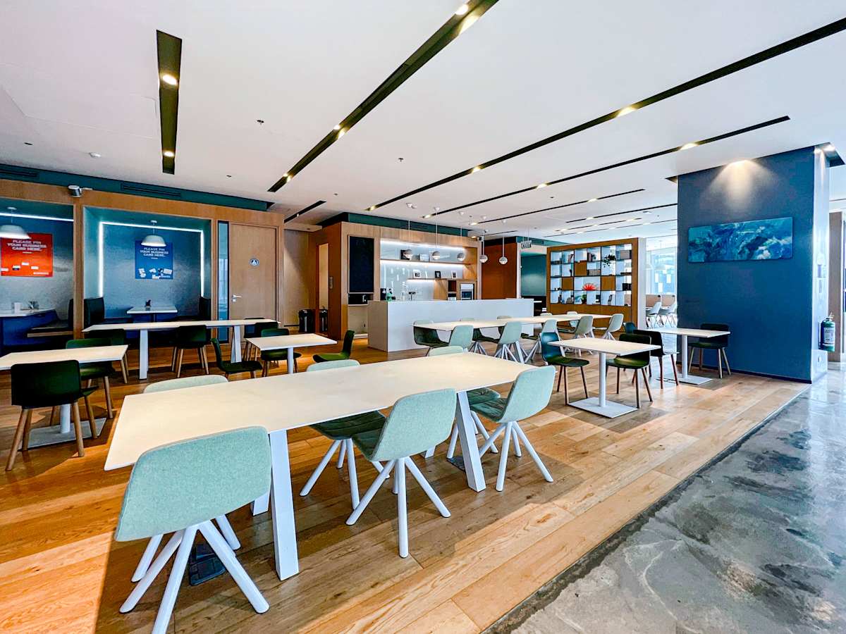 Modern coworking space with open layout, ample seating, and natural lighting on 5th Avenue.