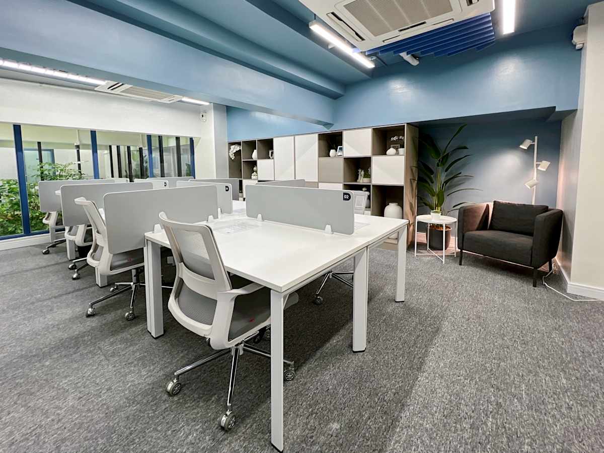 Modern coworking space with sleek desks, ergonomic chairs, and bright natural light.