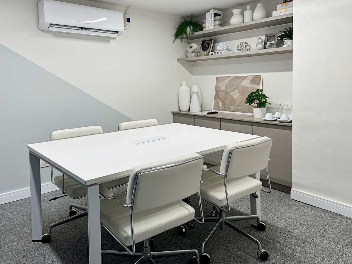 Modern coworking space with sleek white furniture and ample natural light on Quezon Avenue.