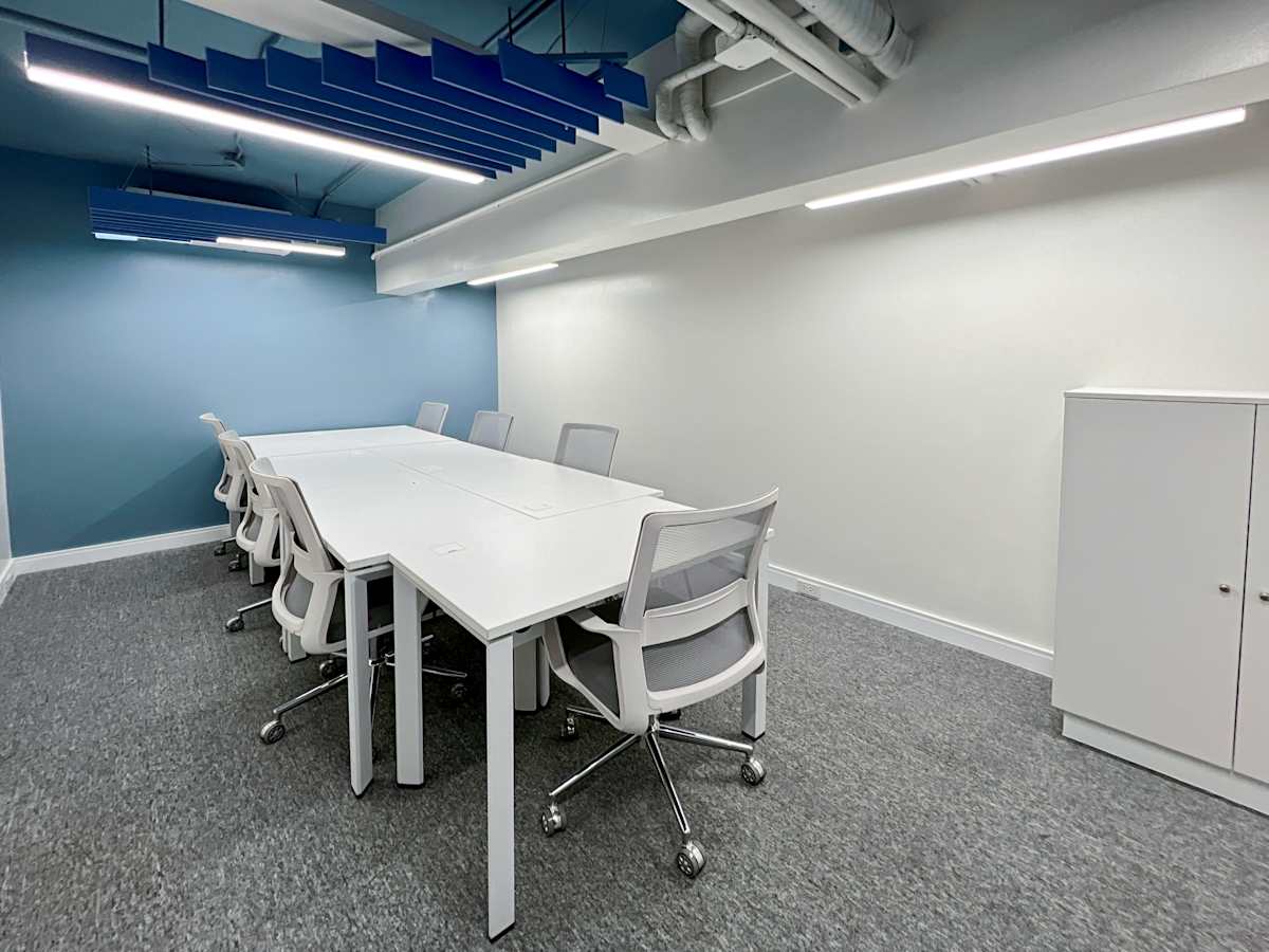 Modern coworking space with sleek white desks, ergonomic chairs, and soft ambient lighting.