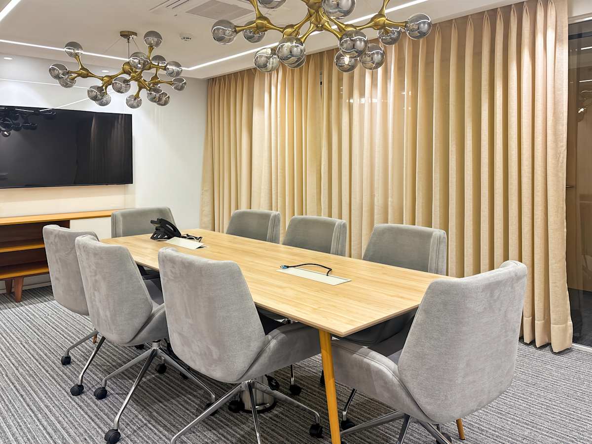 Elegant meeting room with modern lighting, plush seating, and ample natural light. Perfect for collaboration.