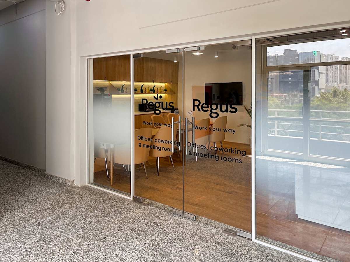 Contemporary coworking space in Noida with modern amenities and glass-fronted meeting rooms.