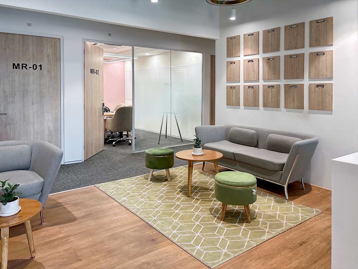 Stylish coworking space with modern seating, glass meeting rooms, and natural light.