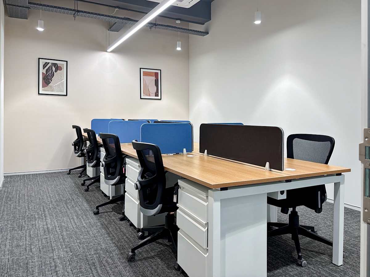 Modern coworking space featuring ergonomic chairs, shared desks, and bright lighting in Noida.