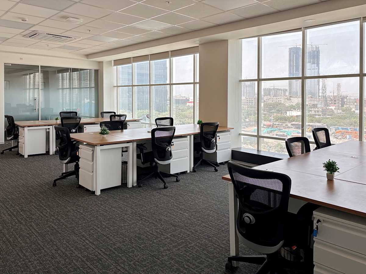 Bright coworking space in Noida with modern furniture and expansive city views.