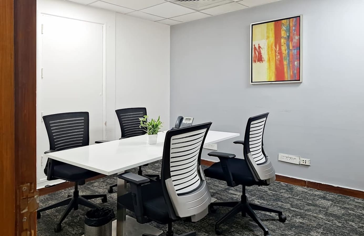 Modern coworking space with ergonomic chairs, natural light, and a vibrant decor.