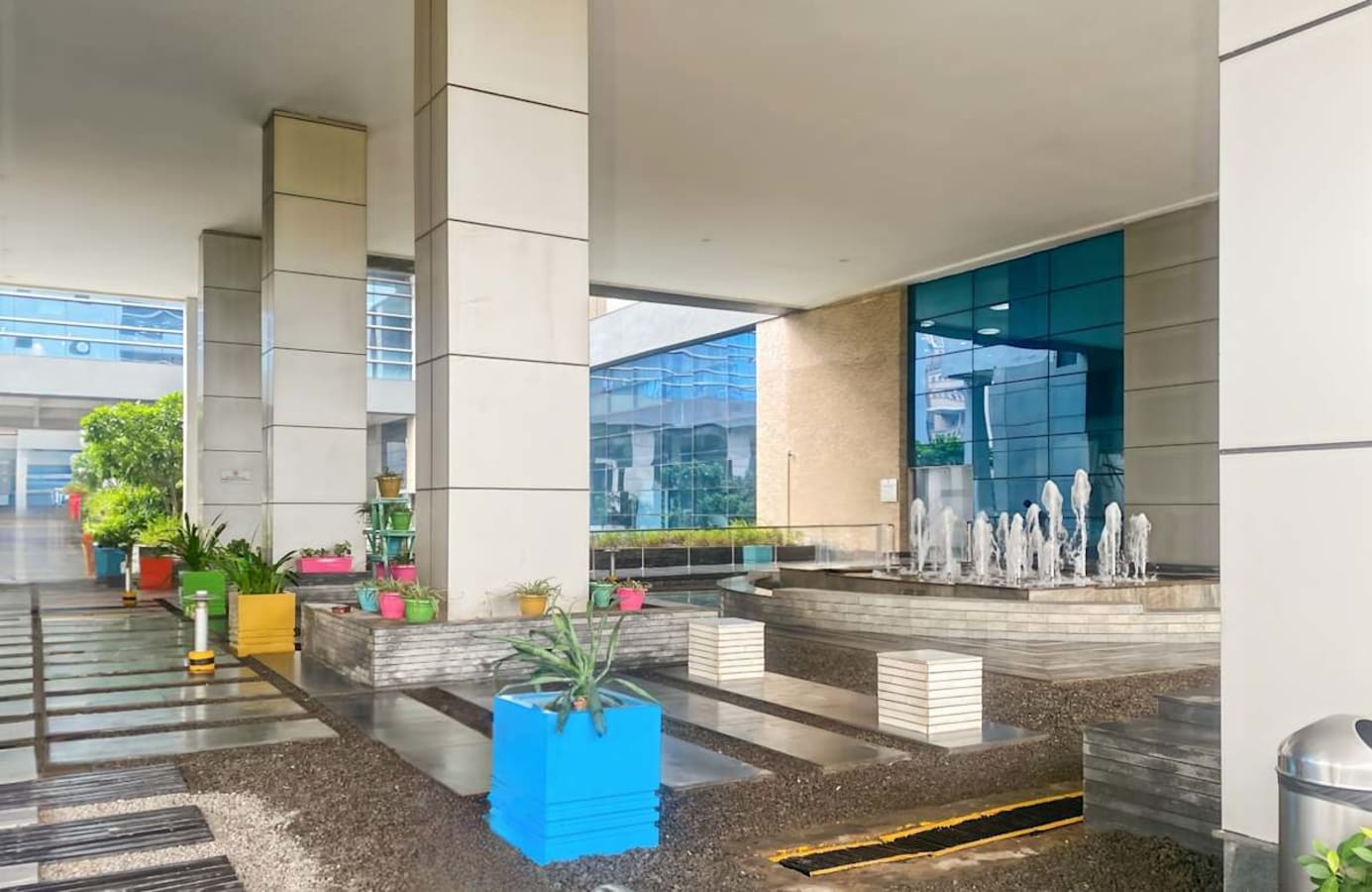 Modern coworking space with vibrant planters and sleek water features in Noida. Perfect for collaboration.