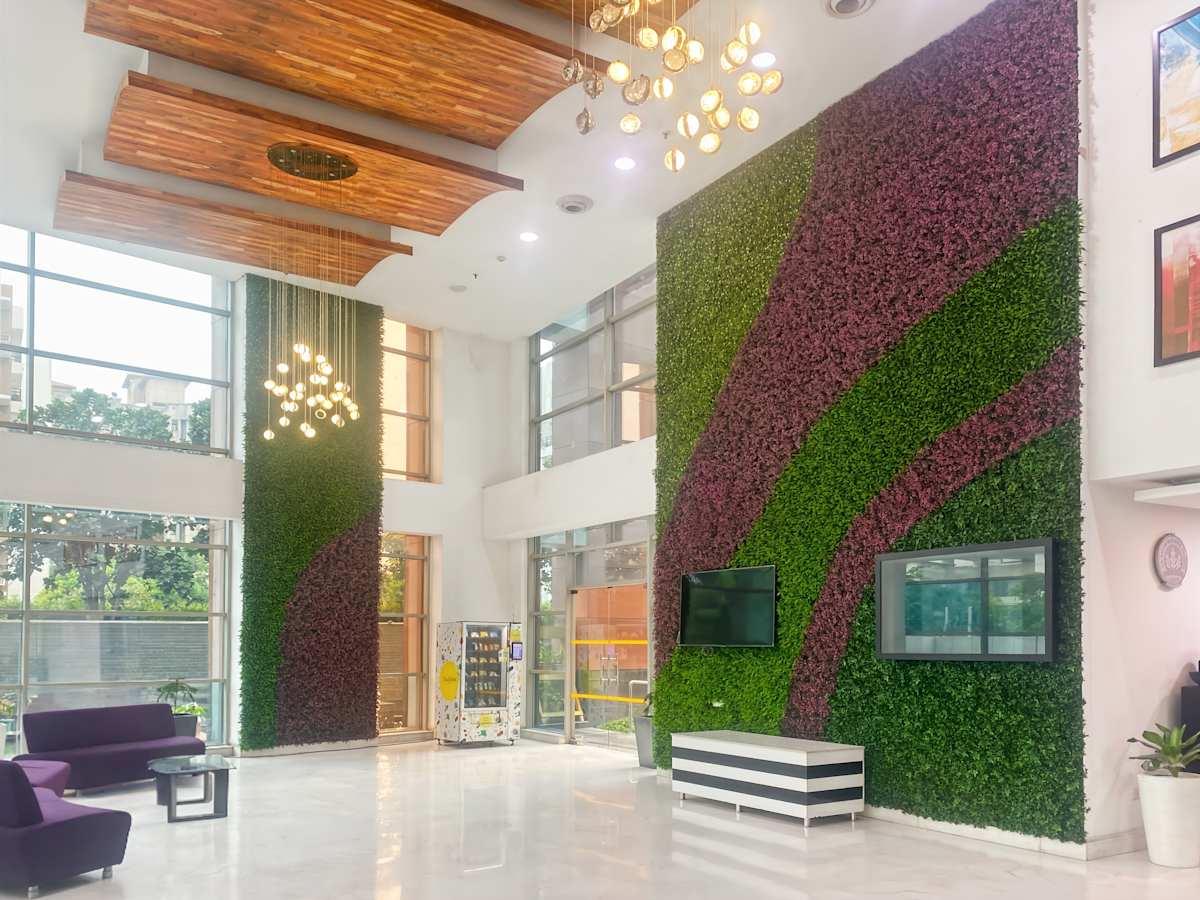 Modern coworking space in Noida with vibrant green walls, sleek seating, and stylish lighting.