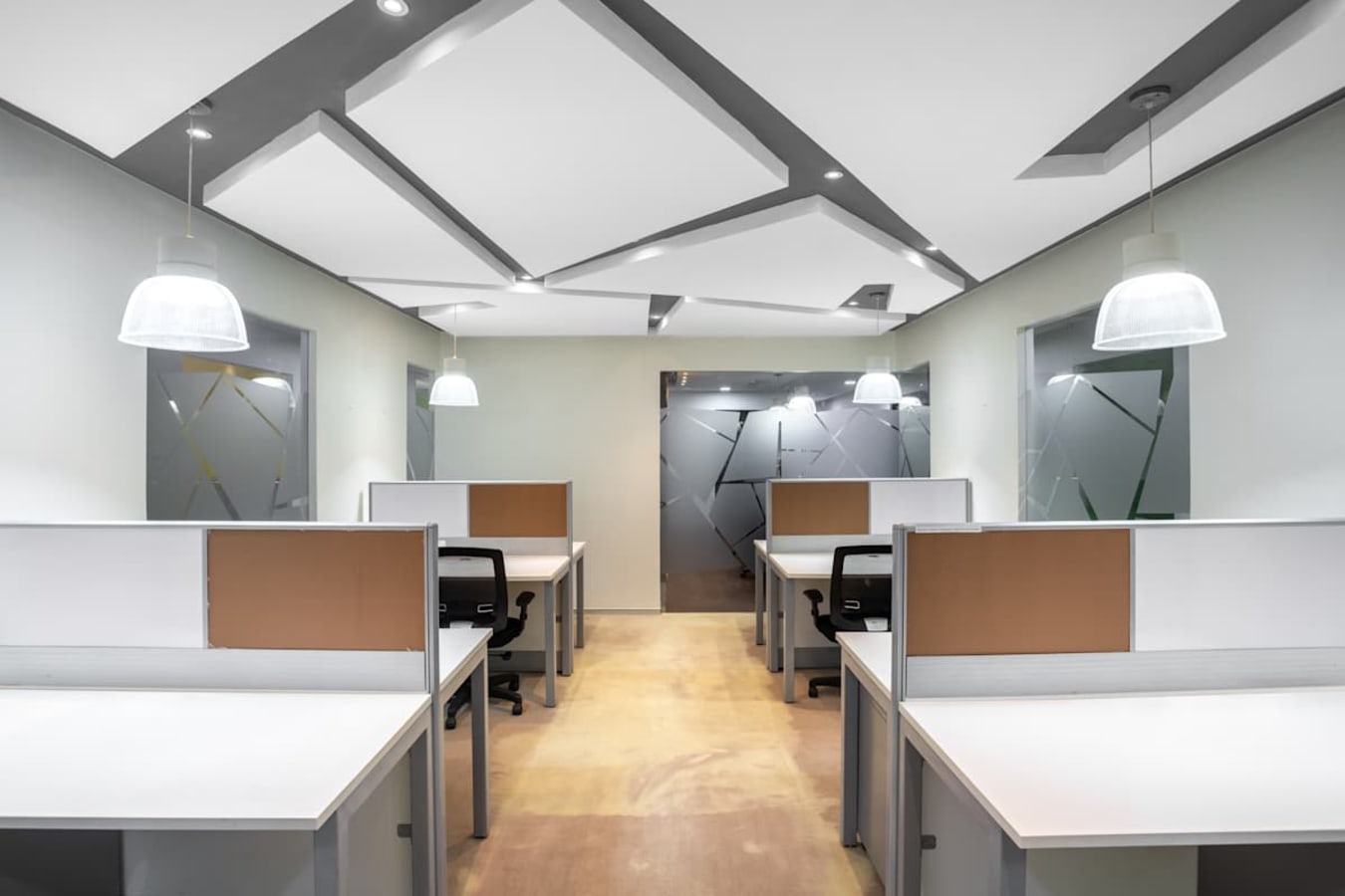 Modern coworking space with sleek design, ample lighting, and dedicated workstations.