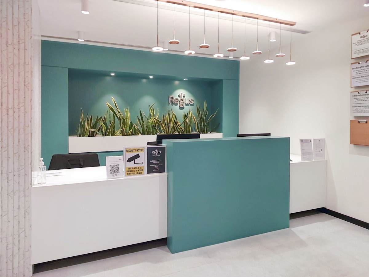 Modern coworking reception area with sleek design and vibrant greenery, ideal for productivity.